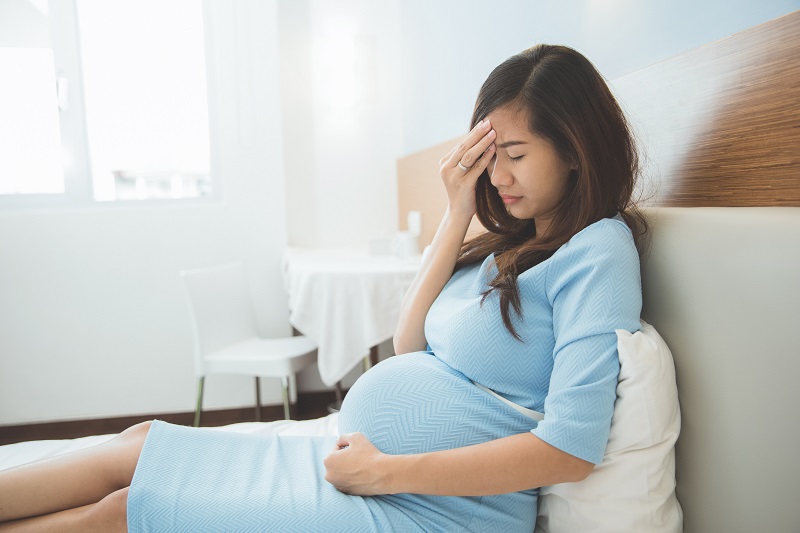 Příznak preeklampsie je bolest hlavy v těhotenství. 