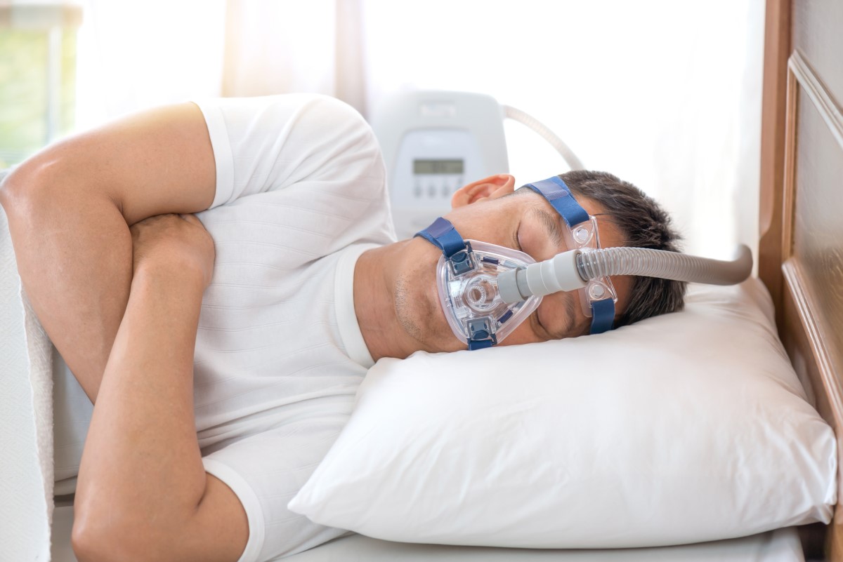 CPAP maska na tvári muža so spánkovým apnoe