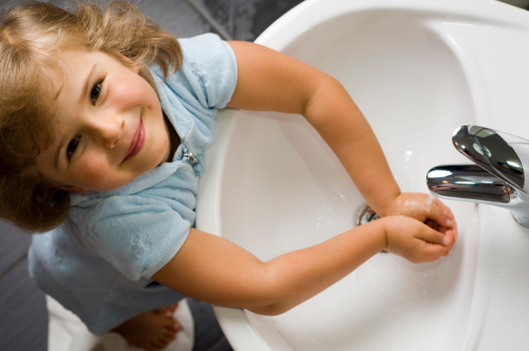 dievčatko si umýva ruky čistou vodou z umývadla