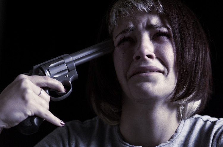 plačúca žena si drží pištol namierenú k hlave