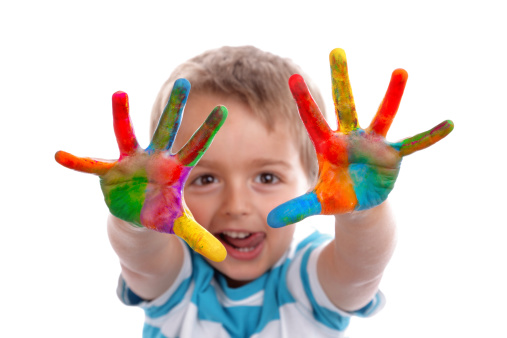Chlapček ukazujúci ruky do objektívu zašpinené farbami
