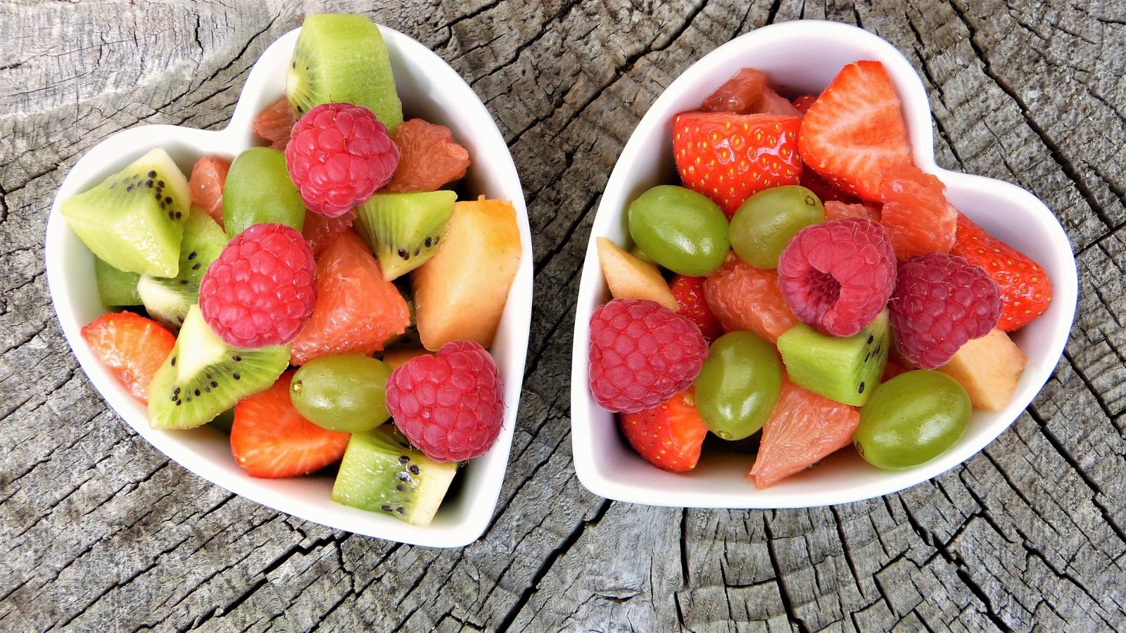 Dve biele misky v tvare srdca plné na kúsky nakrájaného ovocia s obsahom antioxidantov.