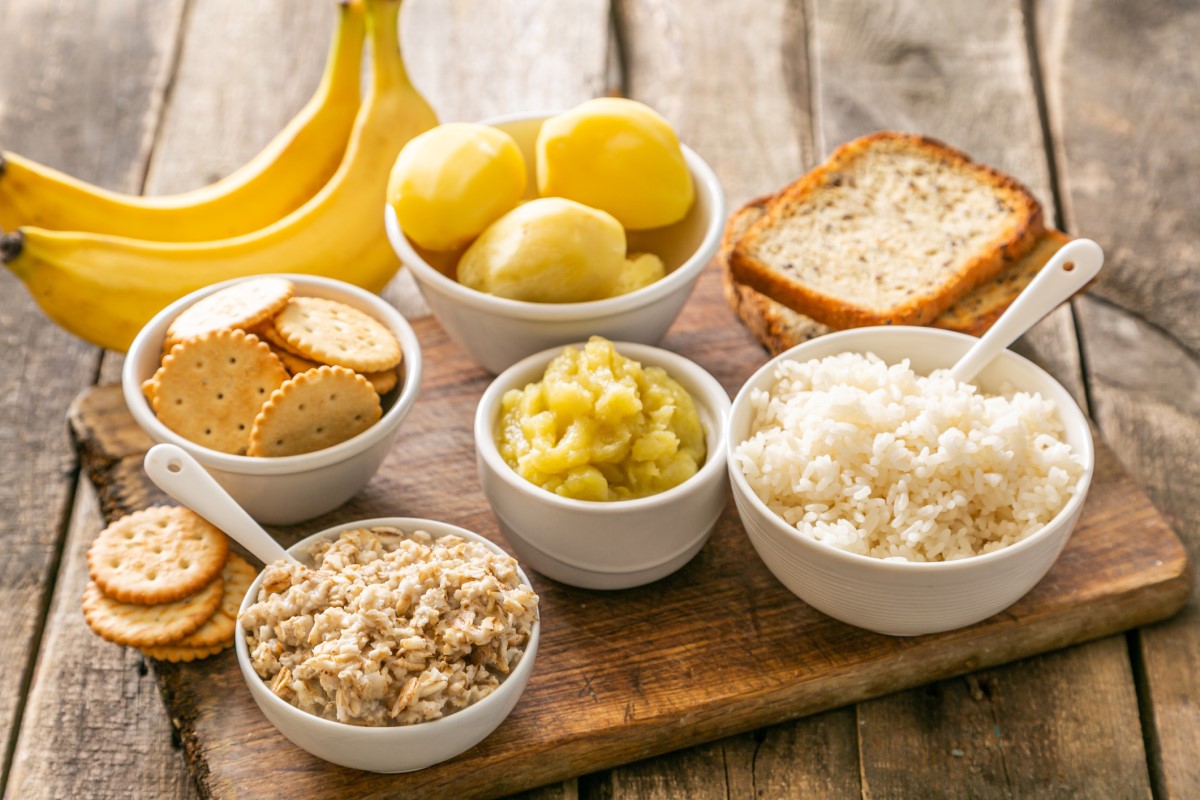 Príklad vhodného jedálnička pri akútnej hnačke - ryža, zemiaky, banány, keksíky, sucháre, v miskách a na drevenej doske