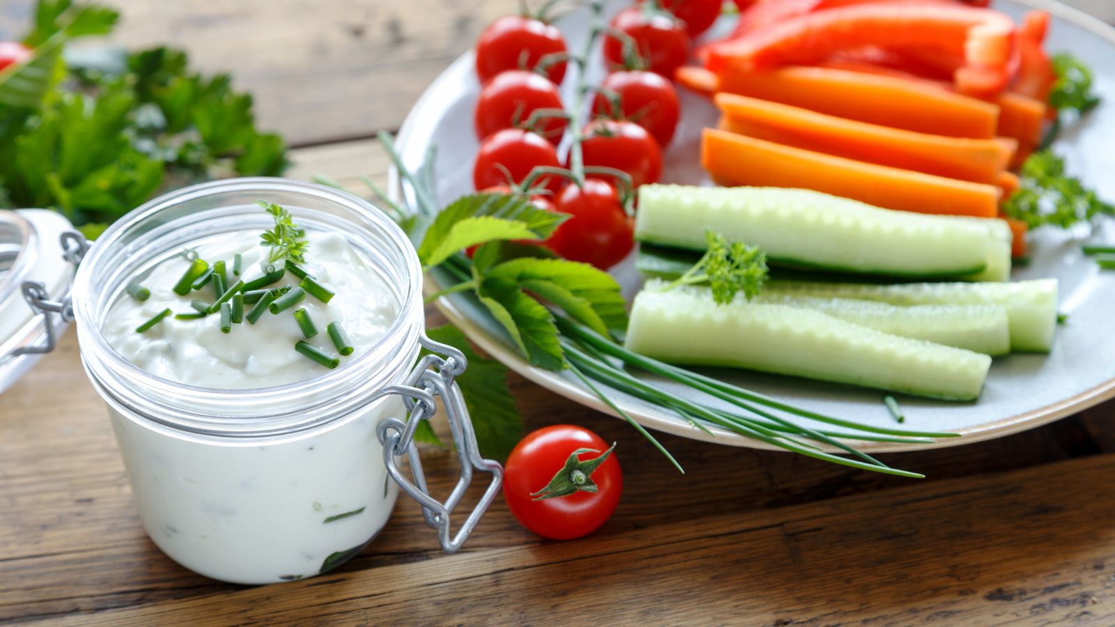 Jogurtový dip s čerstvými bylinkami, podávaný s čerstvou nakrájanou zeleninou, ako uhorka, paprika, rajčina.