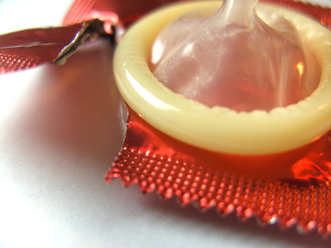 Kondóm vybratý z obalu, roztrhnutý obal, ako prevencia kvapavky a iných pohlavne prenosných ochorení, bariérová antikoncepcia
