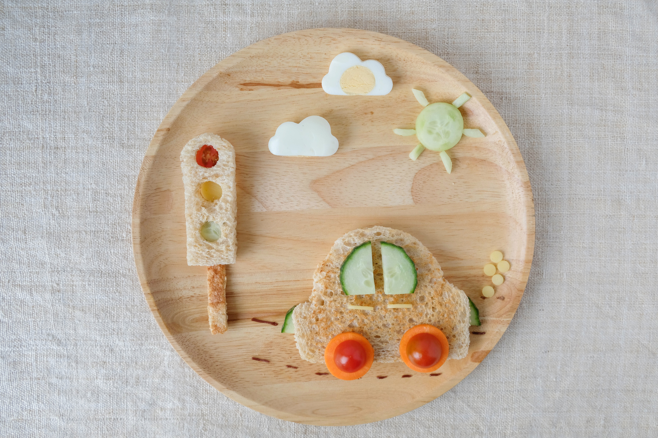 Ľahké občerstvenie na tanieri v tvare autíčka. Rajčiny, mrkva, uhorka, chleba, vajce