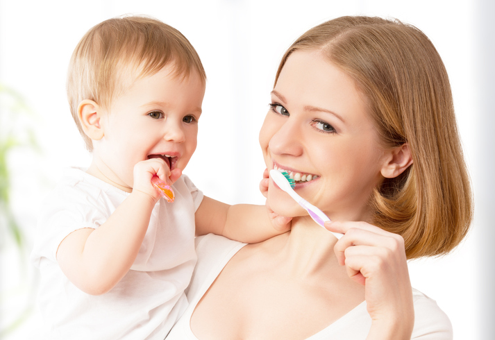 Matka si spolu s dieťaťom na rukách umývajú zuby.