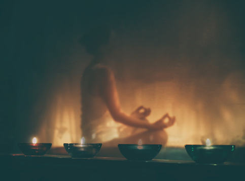 žena medituje pri sviečkach