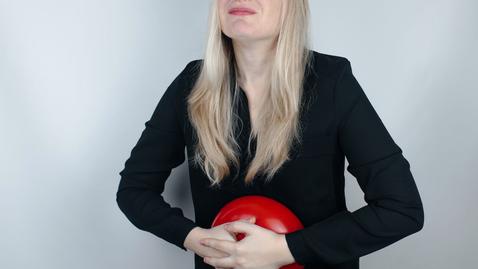 Počúvajte svoje telo a jeho signály, niečo pomôže a iné uškodí. Zdroj foto: Canva Žena má bolesti brucha, drží si brucho a balón ako symbol ťažkostí s trávením