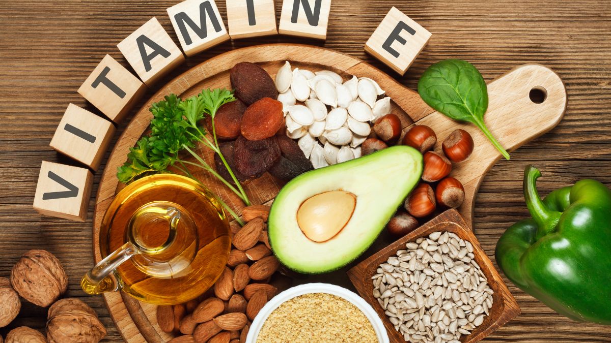 Vitamín E a antioxidanty chránia bunkové membrány pred poškodením voľnými radikálmi, čo pomáha spomaliť mentálny pokles súvisiaci s vekom. Zdroj foto: Canva Na obrázku nápis vitamín E, okolo potraviny s obsahom vitamínu E. Hlavne orechy a semienka a iné.