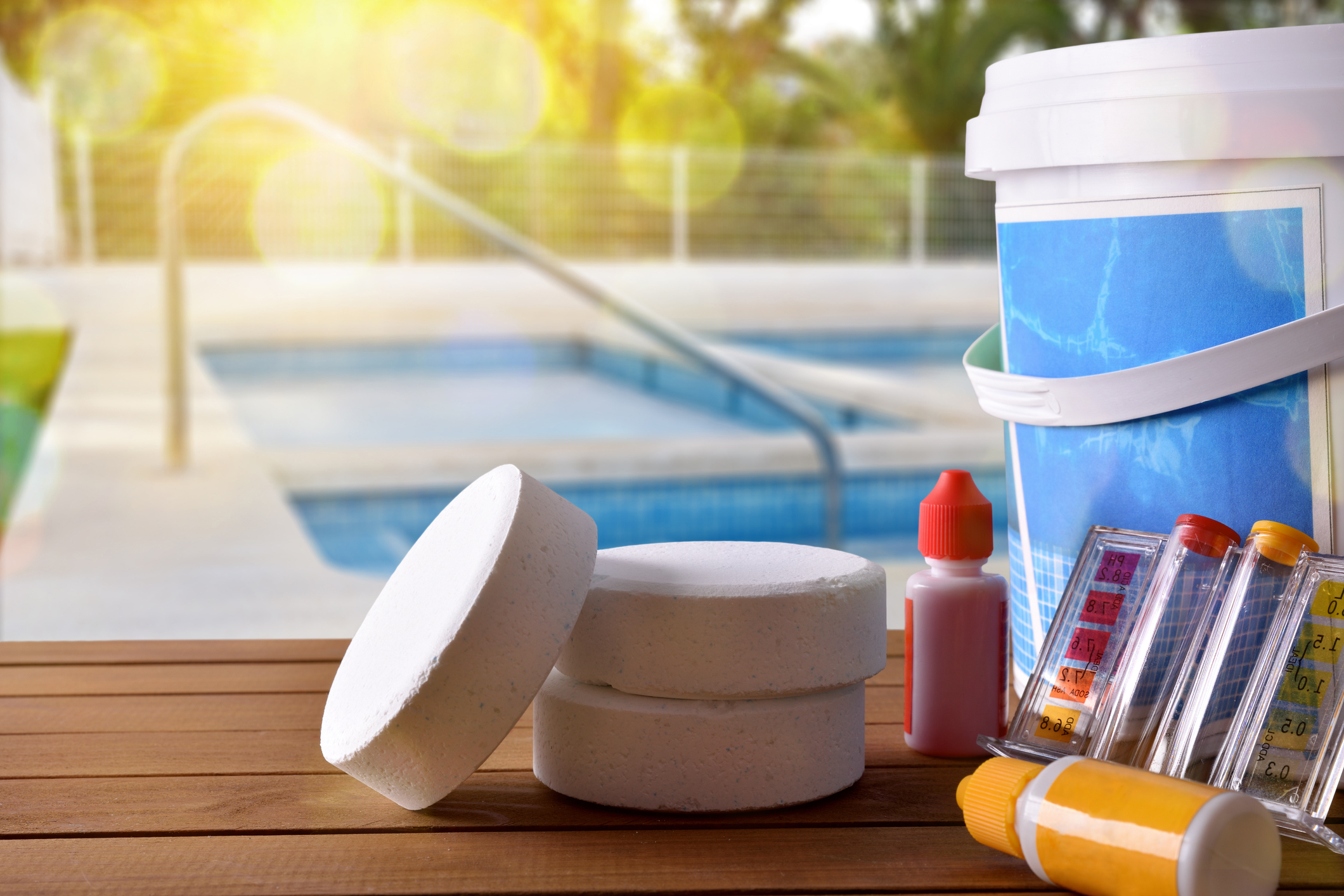 Prípravky a chemikálie na ošetrenie vody v bazéne, bazén v pozadí