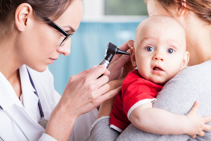 lekárka prístrojom vyšetruje dieťaťu uško