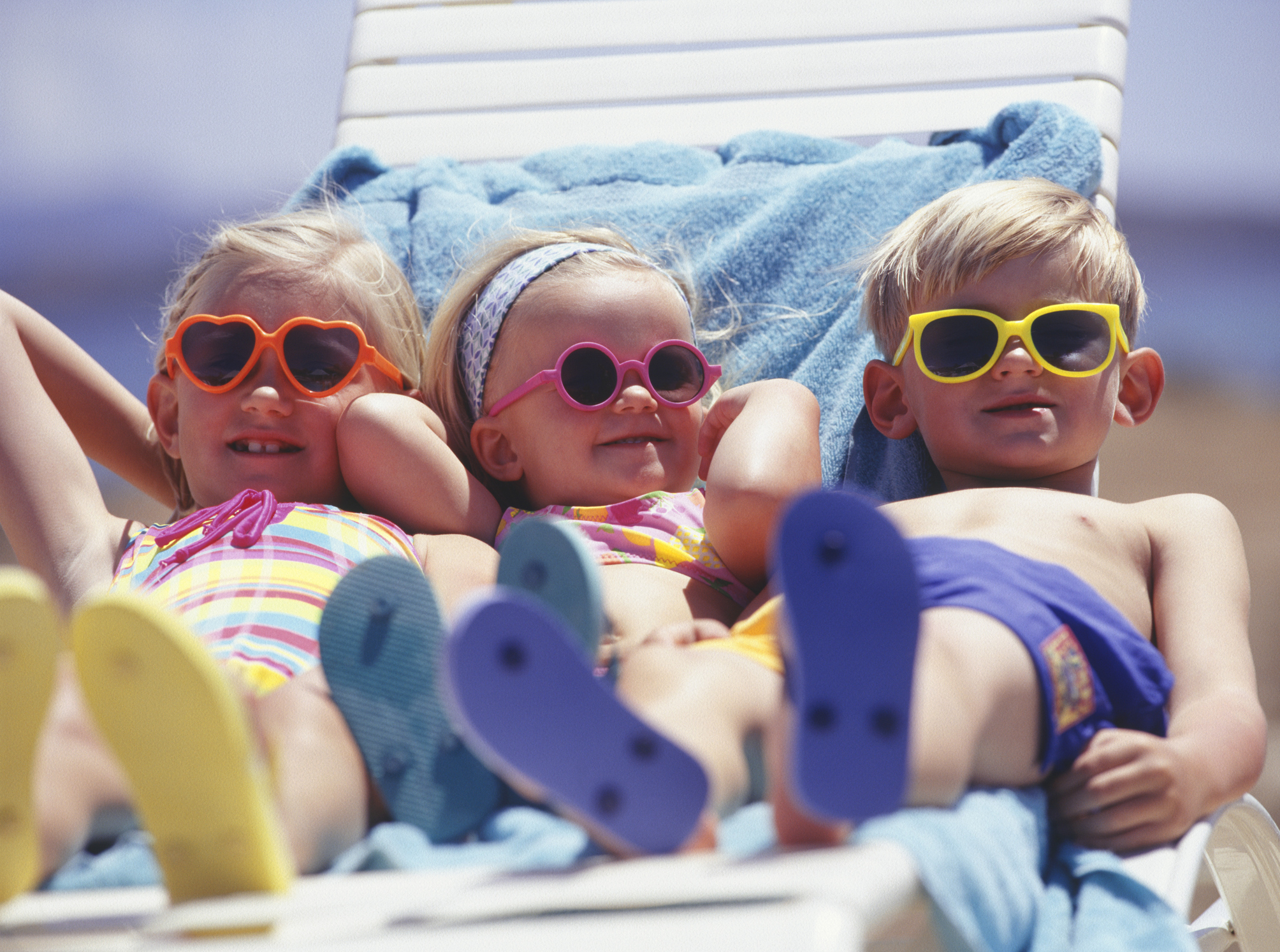 Tri deti na lehátku v slnečných okuliaroch