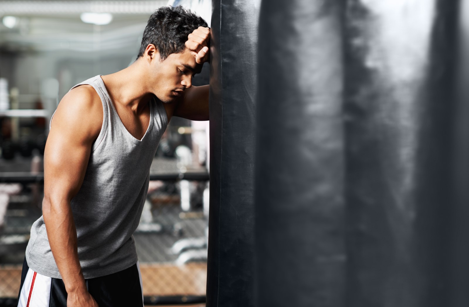 Únava počas tréningu? Na sladkosti radšej zabudnite. Zdroj foto: Shutterstock Muž je unavený, opiera sa o boxerské vrece