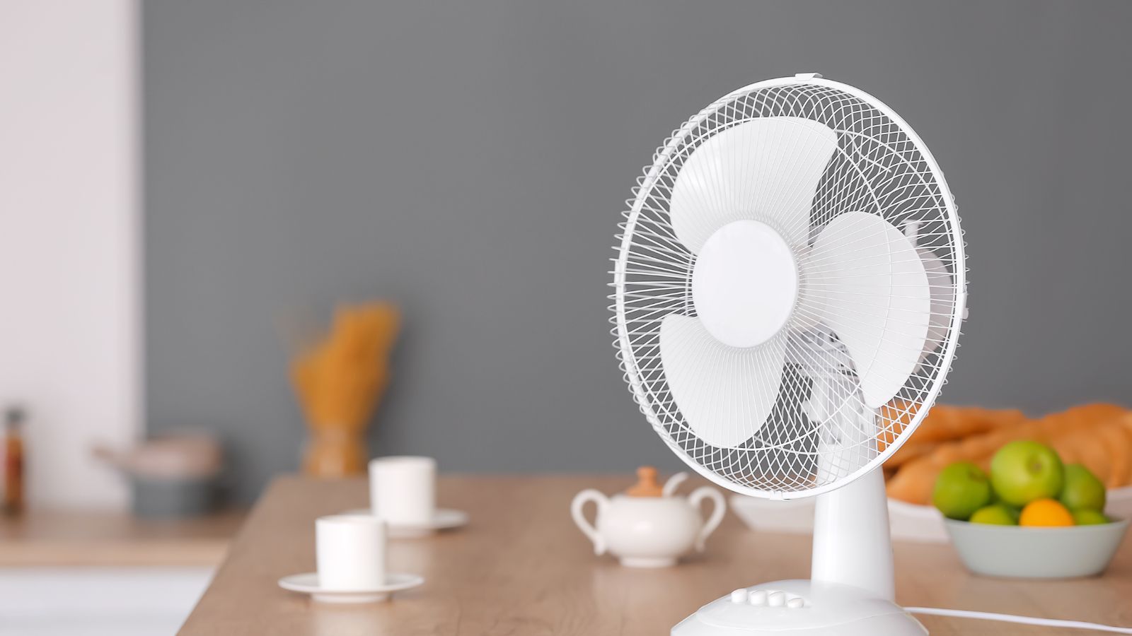 Ak máte doma ventilátor, zaveste pred neho vlhký uterák - vzduch sa tak príjemne zvlhčí a ochladí. Zdroj foto: Canva Ventilátor položený na stole v kuchyni.