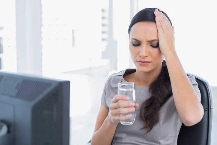 Žena má bolesti hlavy pre dehydratáciu
