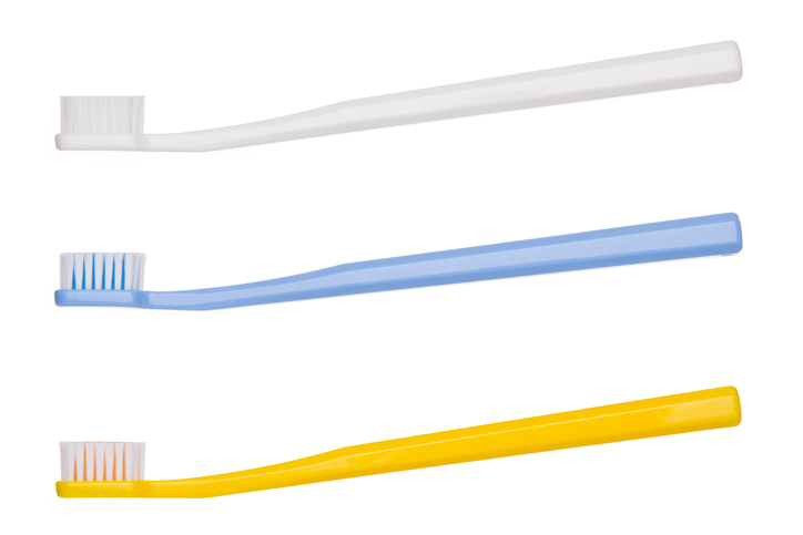 Tri vhodné zubné kefky, biela hore, uprostred modrá a spodná žltá