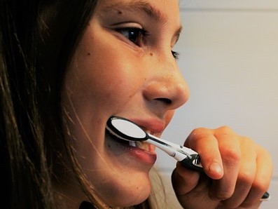 a girl is brushing her teeth