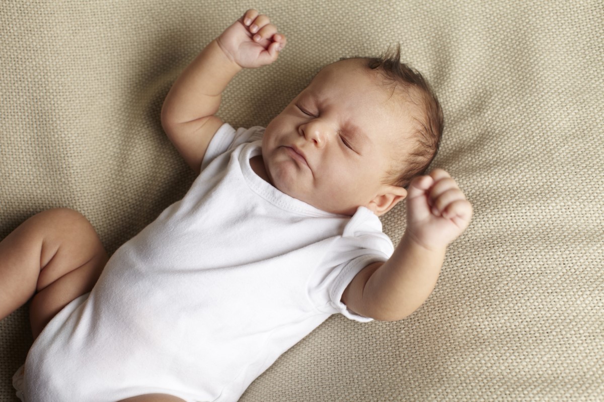 Je kýchanie u novorodencov bežné? Dieťa leží na pohovke