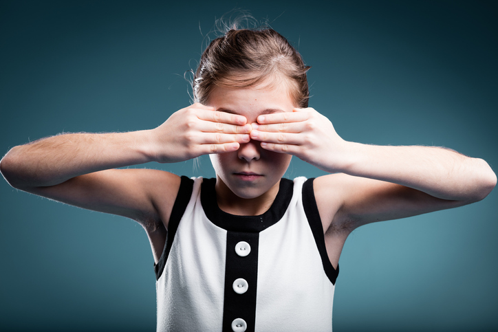 mladé dievča si zakrýva oči ako náznak slepoty