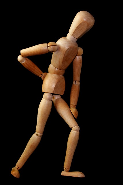 Drevený model panáka, ukazuje na bolesť krížov