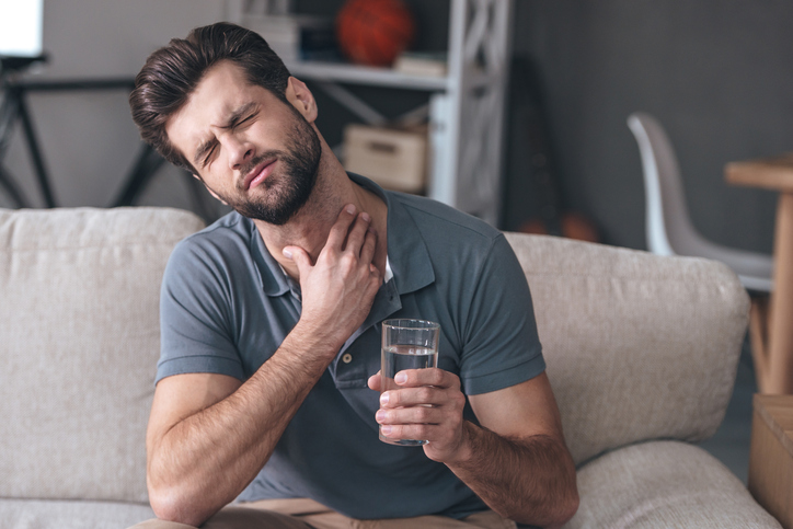 A man has sore throat - worsened by drinking water