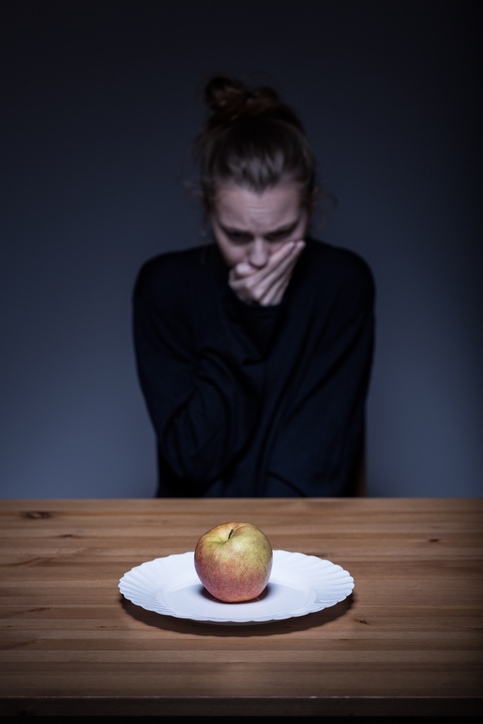 Žena odmieta jedlo, na tanieri je jablko, nechutenstvo